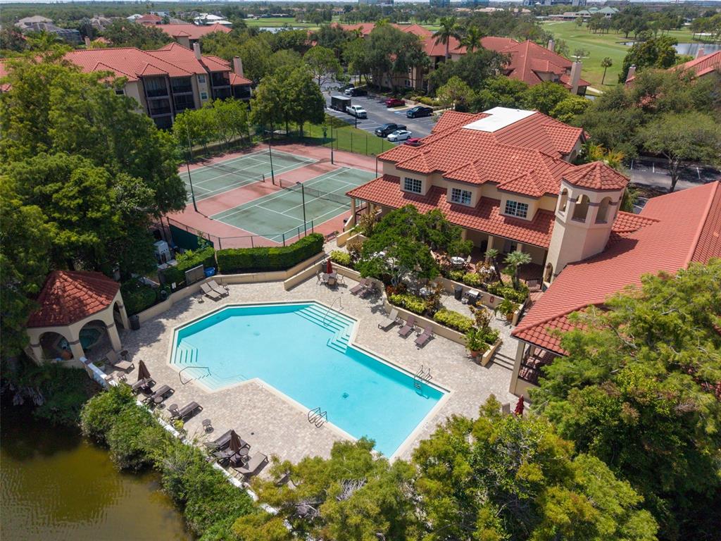 An aerial view shows a swimming pool, tennis courts, and a clubhouse with tiled roofs — 2400 FEATHER SOUND DRIVE UNIT 236, CLEARWATER, FL