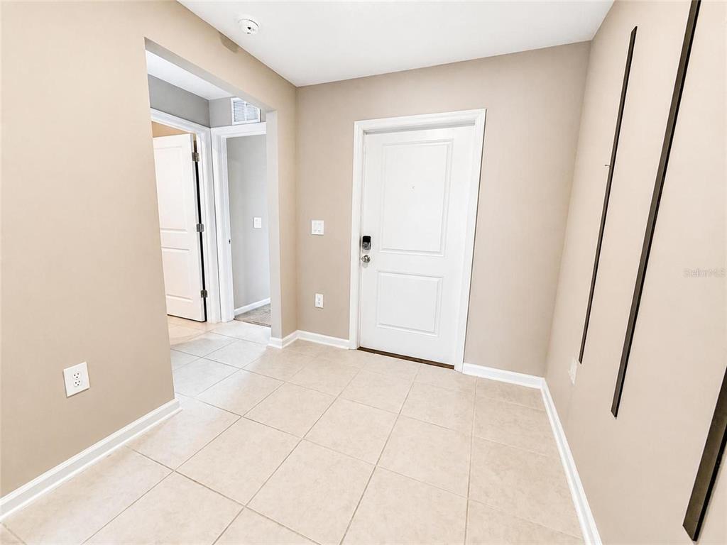 An entryway with beige walls, tile flooring, and a white front door — 2862 PENNACHIO DRIVE, LAKE WALES, FL