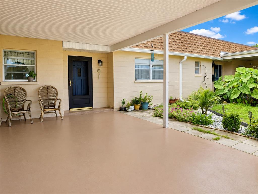 A rectangular outdoor swimming pool with a blue tiled edge sits on a concrete deck — 617 PARK CIRCLE UNIT 26, BRADENTON, FL