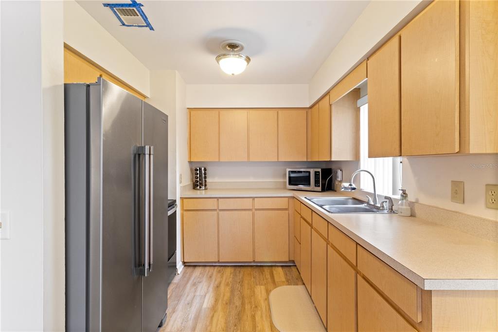 A kitchen with light wood cabinets, stainless steel appliances, and laminate countertops — 3014 VENICE WAY, LAKELAND, FL