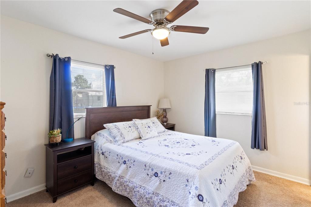 A bedroom features a queen bed, two nightstands, two windows with curtains, and a ceiling fan — 3014 VENICE WAY, LAKELAND, FL