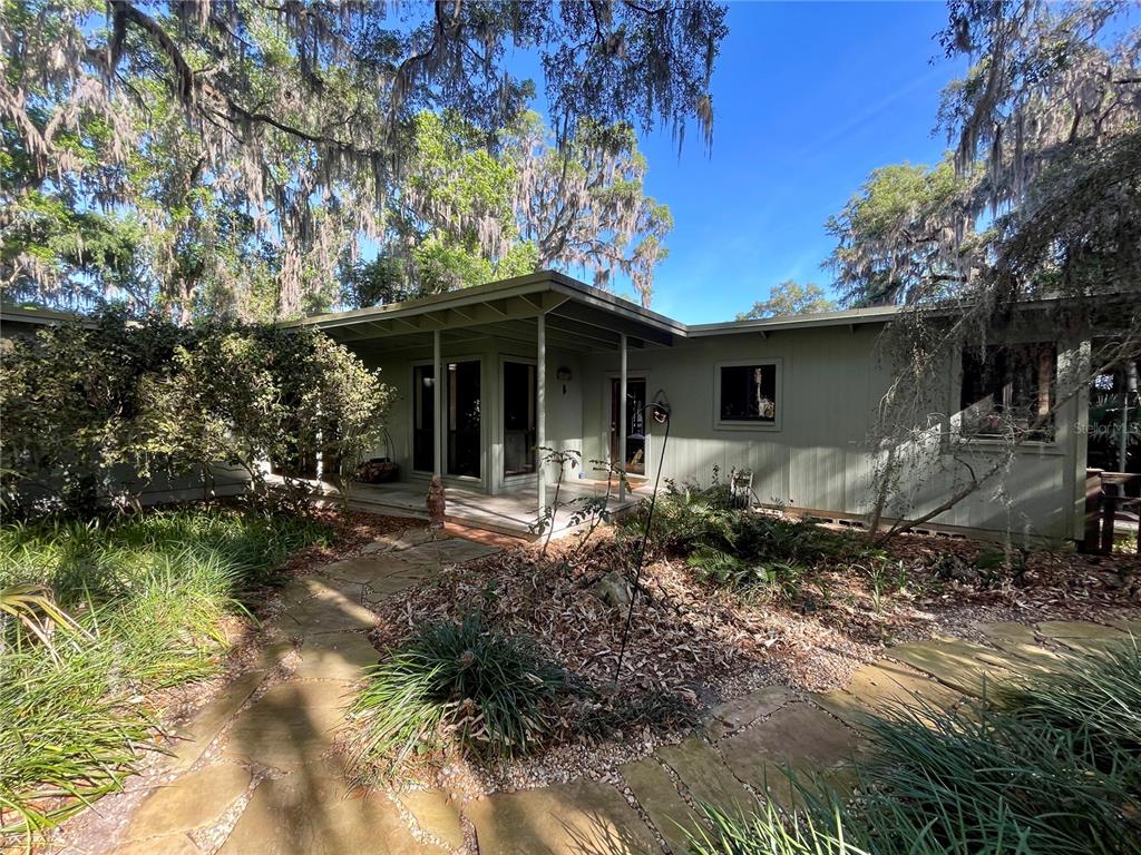 A single-story house with light green siding and a stone path leading to the porch — 1800 SW 35TH PLACE, GAINESVILLE, FL