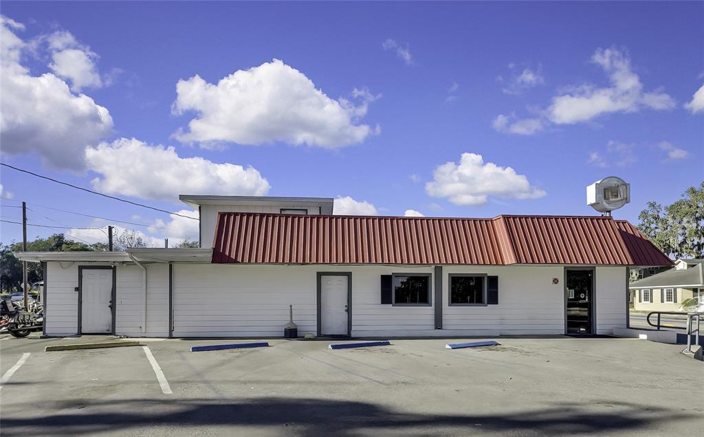 A single-story commercial building with a red metal roof and a parking lot in front — 104 US HIGHWAY 41 S, INVERNESS, FL