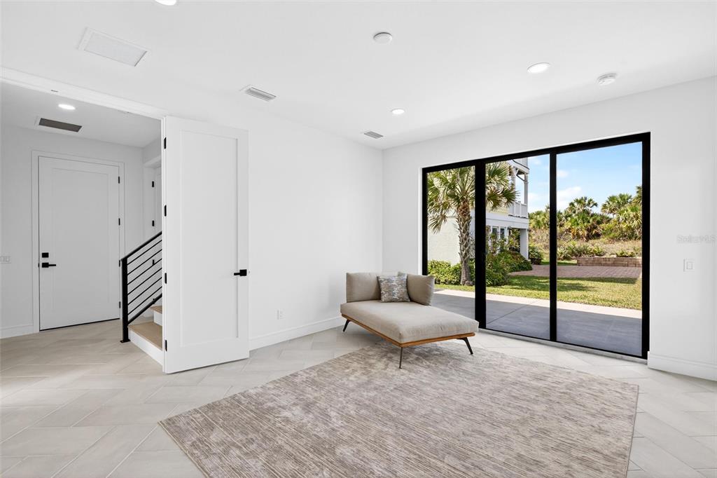 A bright room with light tile flooring, a chaise lounge, and sliding glass doors to outdoors — 2946 N OCEAN SHORE BOULEVARD, FLAGLER BEACH, FL