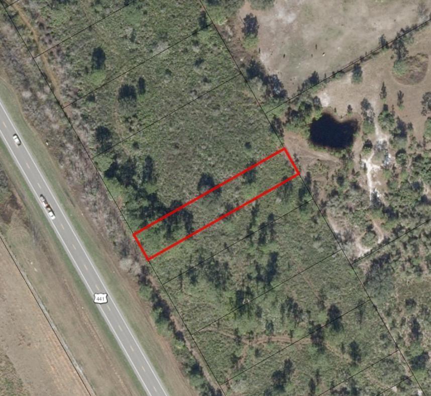 An aerial view shows a rectangular plot of land highlighted in red next to a highway — 0 NW 24th Drive, Okeechobee FL 34972, OKEECHOBEE, FL
