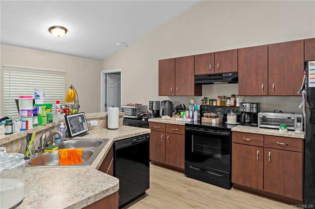 A kitchen features wood cabinets, laminate countertops, a double sink, and black appliances — 3551 W BURGANDY DRIVE, CITRUS SPRINGS, FL