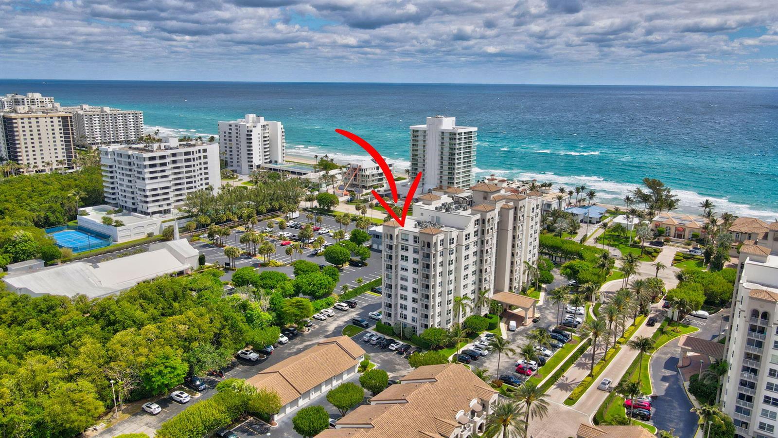 An aerial view shows a multi-story residential building near the ocean with surrounding parking lots — 3594 S Ocean Boulevard # 302, Highland Beach FL 33487, HIGHLAND BEACH, FL