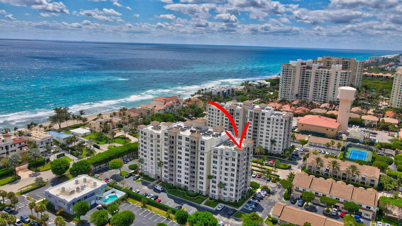 An aerial view of a multi-story residential building near the ocean with a red arrow — 3594 S Ocean Boulevard # 302, Highland Beach FL 33487, HIGHLAND BEACH, FL