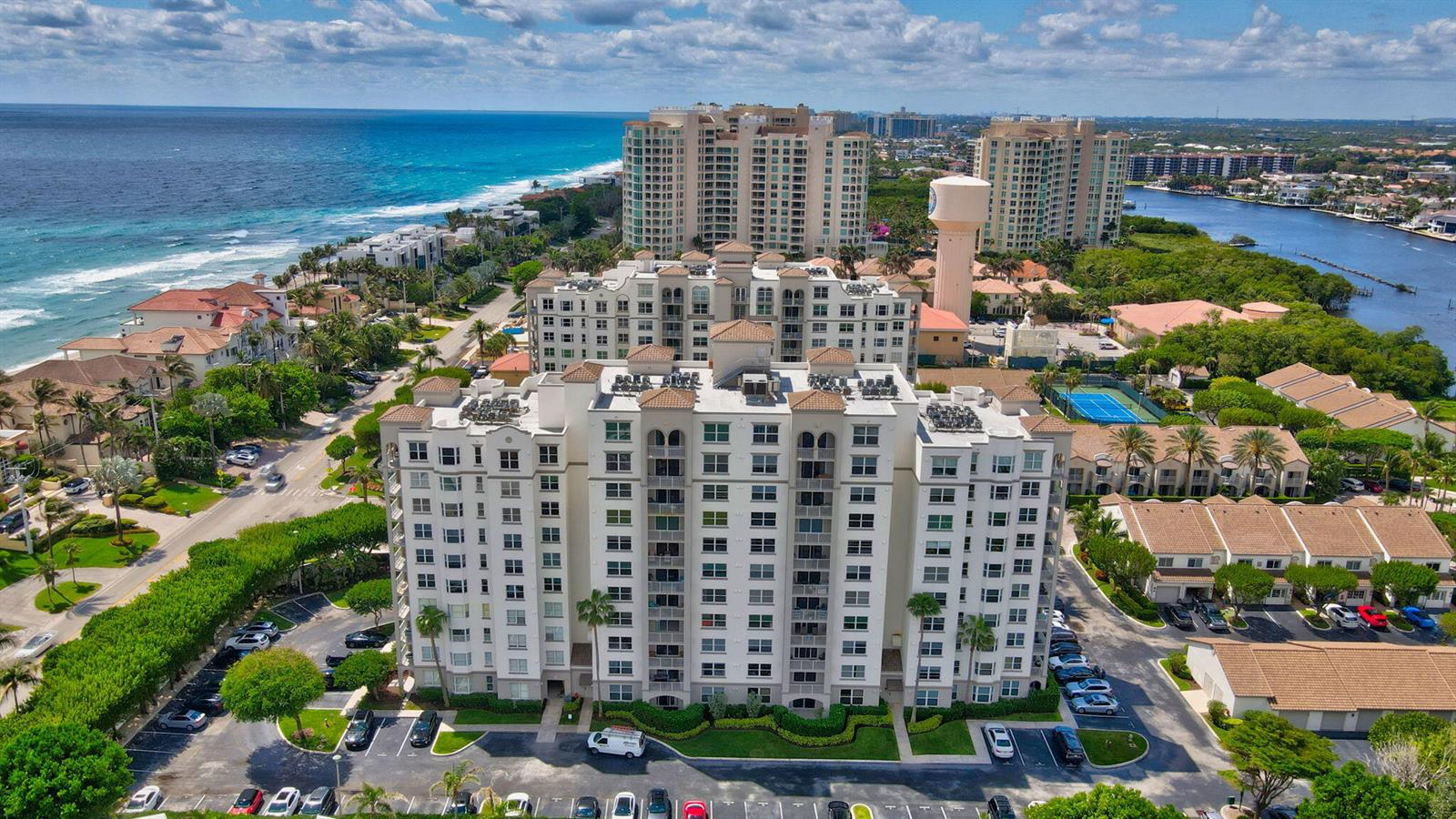 An aerial view shows a large apartment complex near the ocean with parking lots — 3594 S Ocean Boulevard # 302, Highland Beach FL 33487, HIGHLAND BEACH, FL