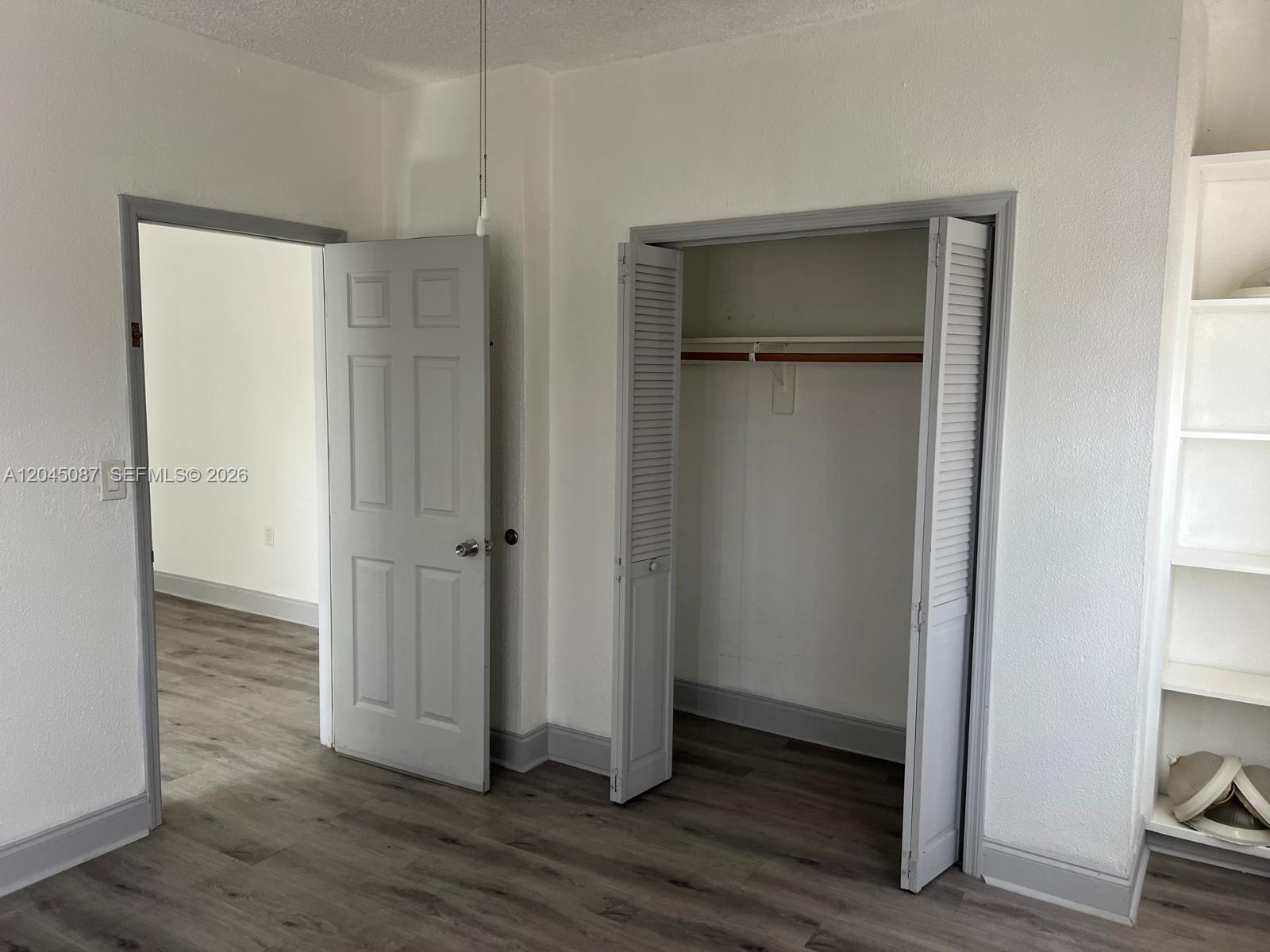A room features gray wood-look flooring, white walls, a closet, and an open doorway — 1322 SW 7th St # 8, Miami FL 33135, MIAMI, FL