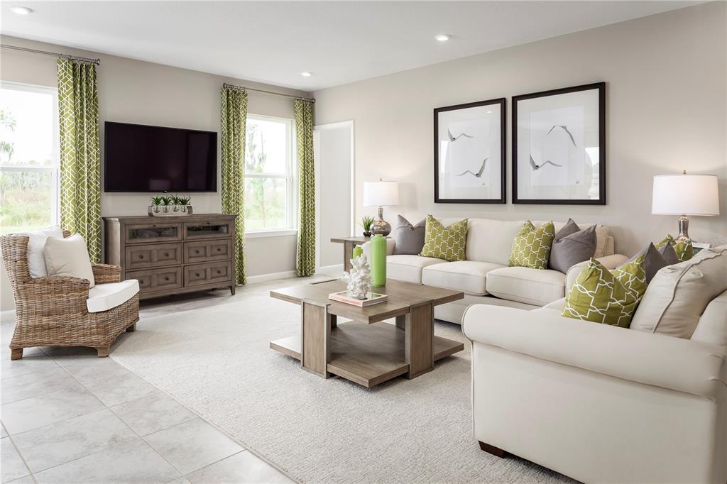 A living room features a beige sofa, a wicker armchair, and green patterned curtains — 1739 UPLAND LANE, WINTER HAVEN, FL