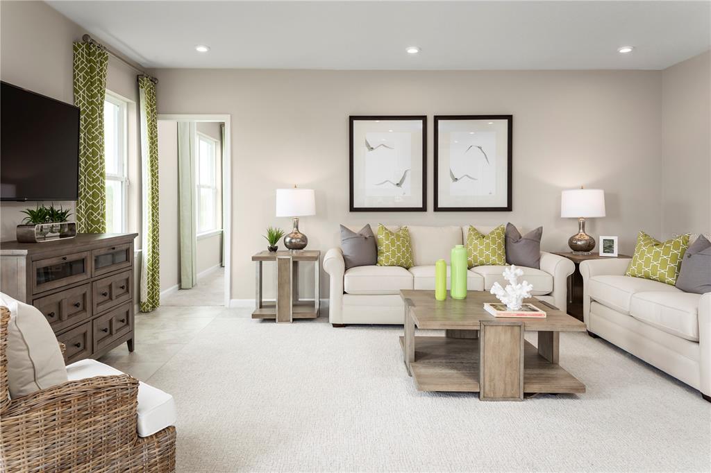 A living room features beige sofas, green patterned pillows, a wooden coffee table, and curtains — 1739 UPLAND LANE, WINTER HAVEN, FL