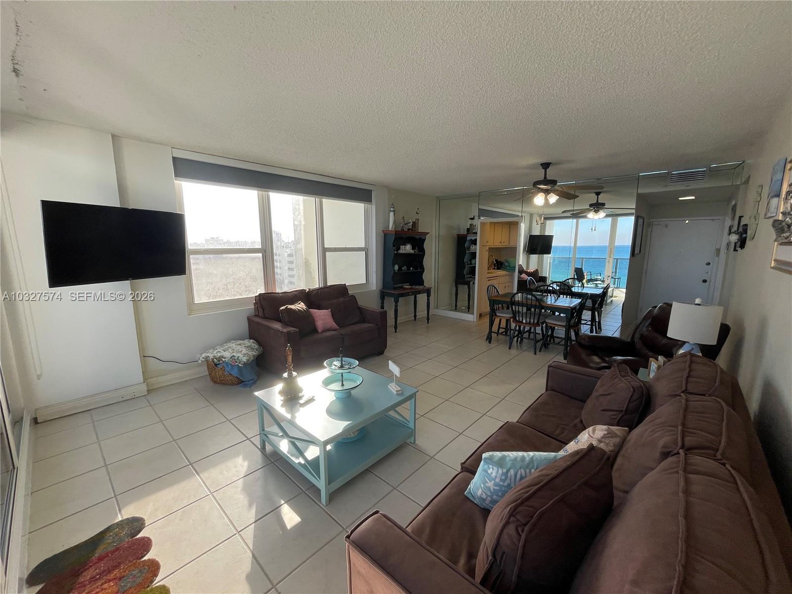 A living room with tile floors, brown sofas, a light blue coffee table, and ocean views — 3505 S Ocean Dr # 921, Hollywood FL 33019, HOLLYWOOD, FL