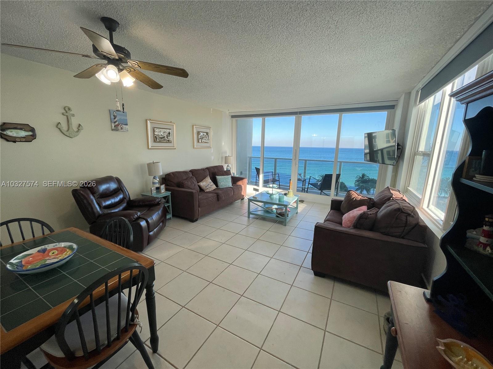 A living room with tile floors and a dining area overlooks the ocean through windows — 3505 S Ocean Dr # 921, Hollywood FL 33019, HOLLYWOOD, FL