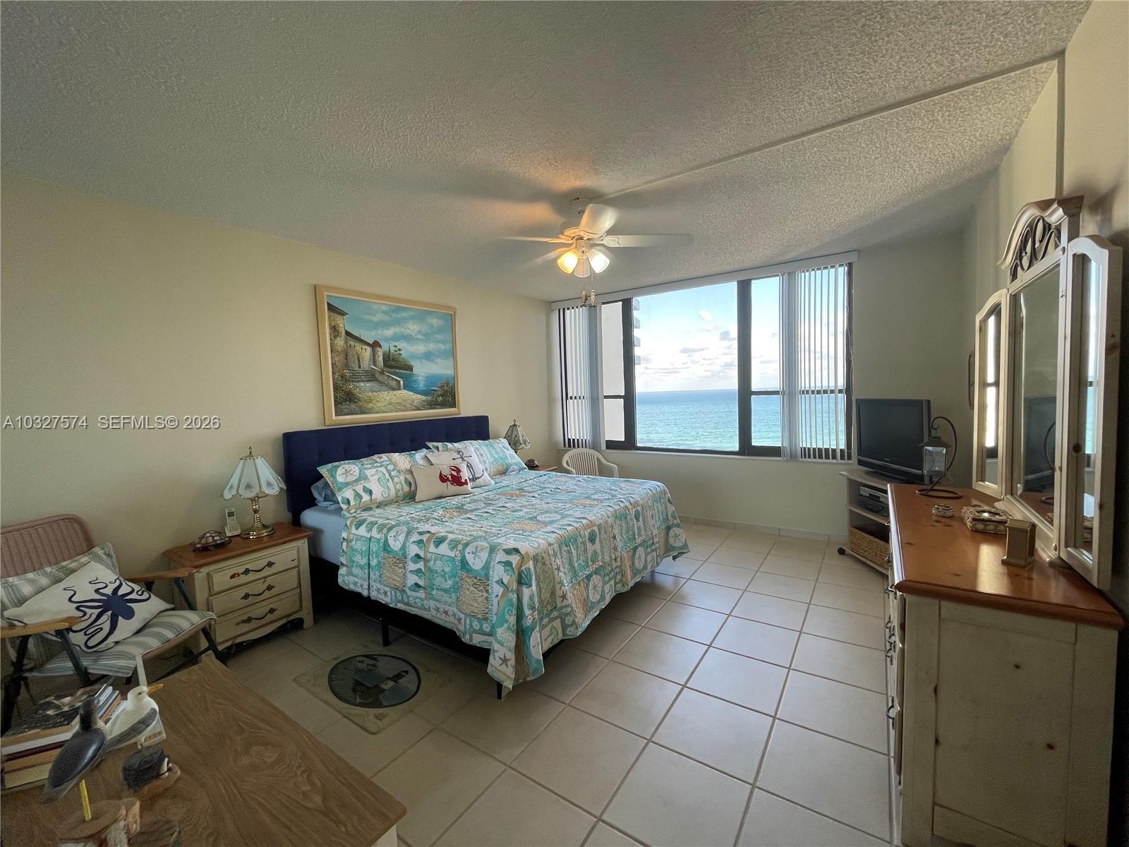 A bedroom with tile floors, a bed, and a large window overlooking the ocean — 3505 S Ocean Dr # 921, Hollywood FL 33019, HOLLYWOOD, FL