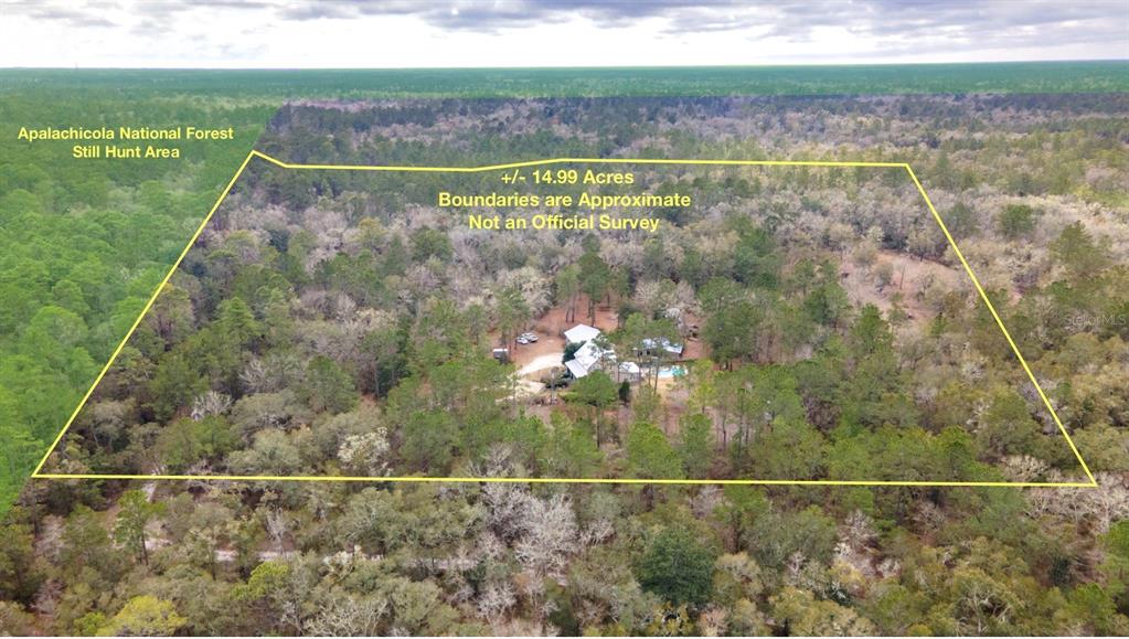 An aerial view shows a house on a wooded lot bordering the Apalachicola National Forest — 210 TUCKER SPRINGS ROAD, SOPCHOPPY, FL