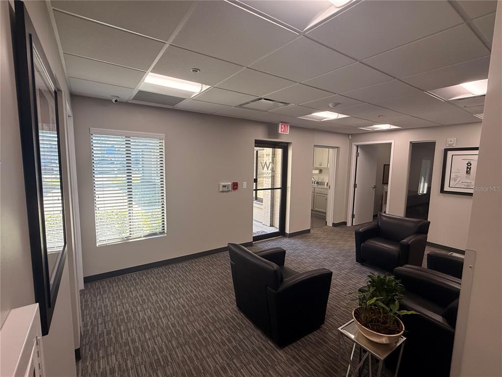 A waiting room features black leather chairs, a small side table with a plant, and carpet — 30522 US HIGHWAY 19 N UNIT 105, PALM HARBOR, FL