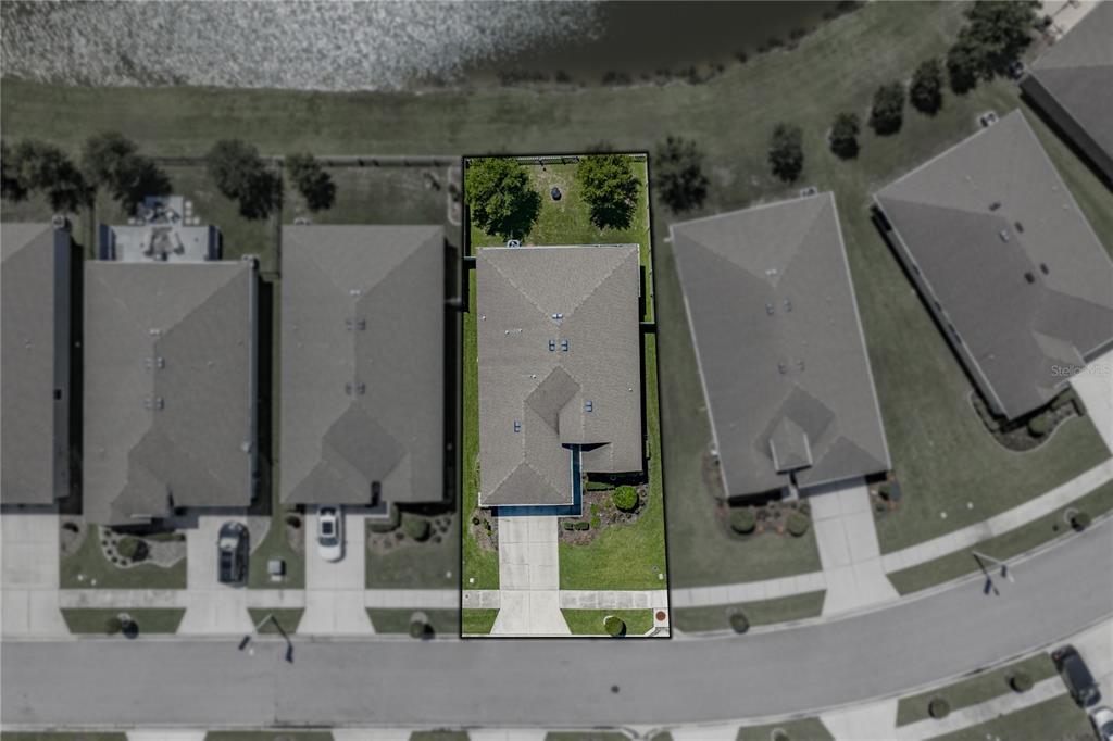 This aerial view shows a single-family home with a fenced backyard and a concrete driveway — 31785 TANSY BEND, WESLEY CHAPEL, FL