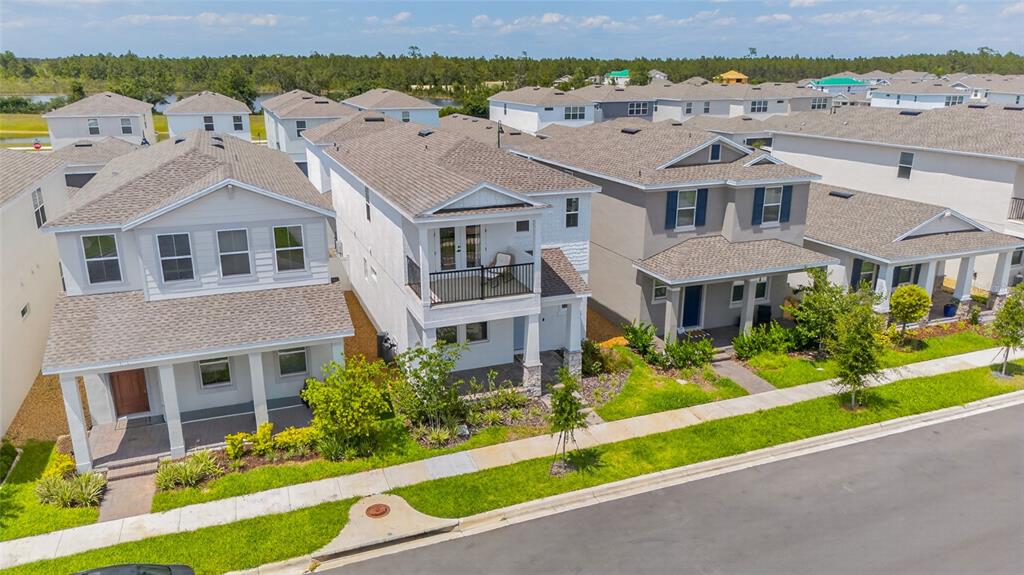 An aerial view shows several two-story suburban houses with gray roofs and green lawns — 15591 GENTLE RAIN DRIVE, WINTER GARDEN, FL