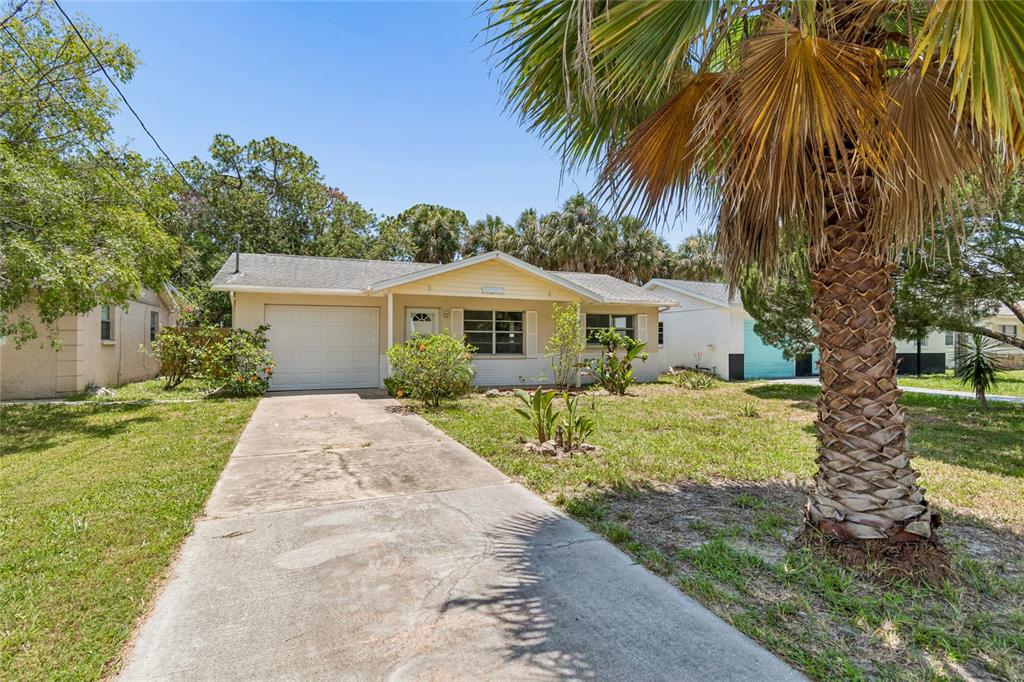 A single-story house with a white brick base, tan siding, and a gray shingled roof — 6826 DRIFTWOOD DRIVE, HUDSON, FL