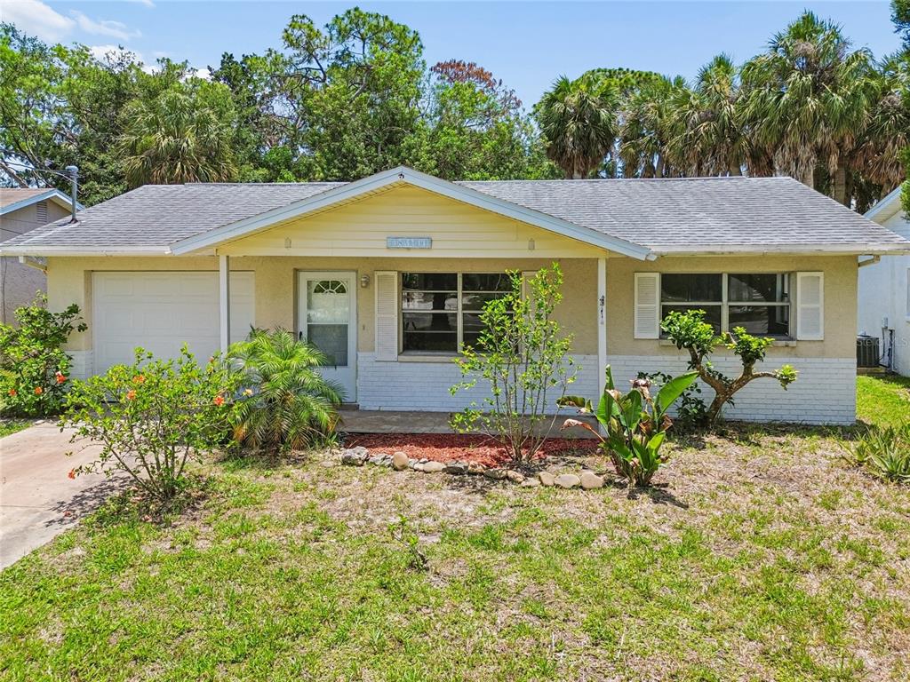 An open-concept living area features wood-look flooring, white walls, and a kitchen with an island — 6826 DRIFTWOOD DRIVE, HUDSON, FL