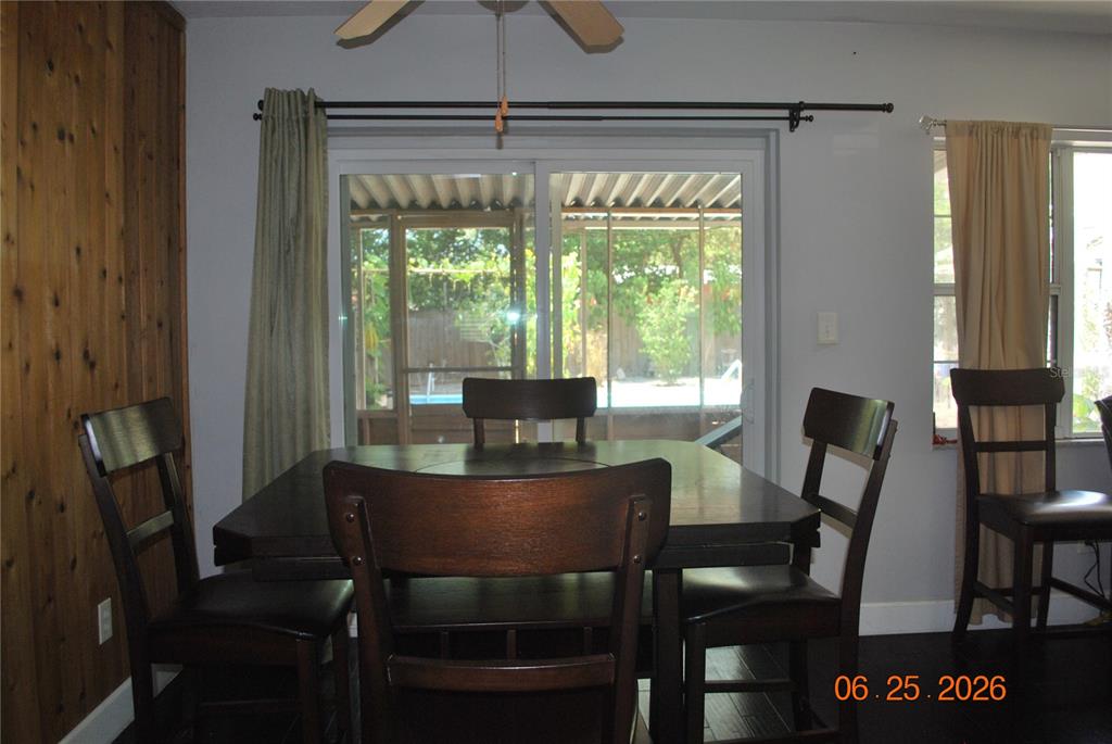 A dining room features a dark wood table, matching chairs, and a sliding glass door — 1515 NEBRASKA AVENUE, PALM HARBOR, FL