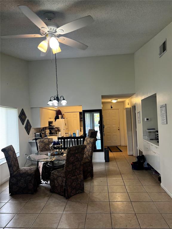 A dining area with a ceiling fan, tiled floors, and an adjacent kitchen — 4400 WHITE PINE AVENUE UNIT 70-4, ORLANDO, FL
