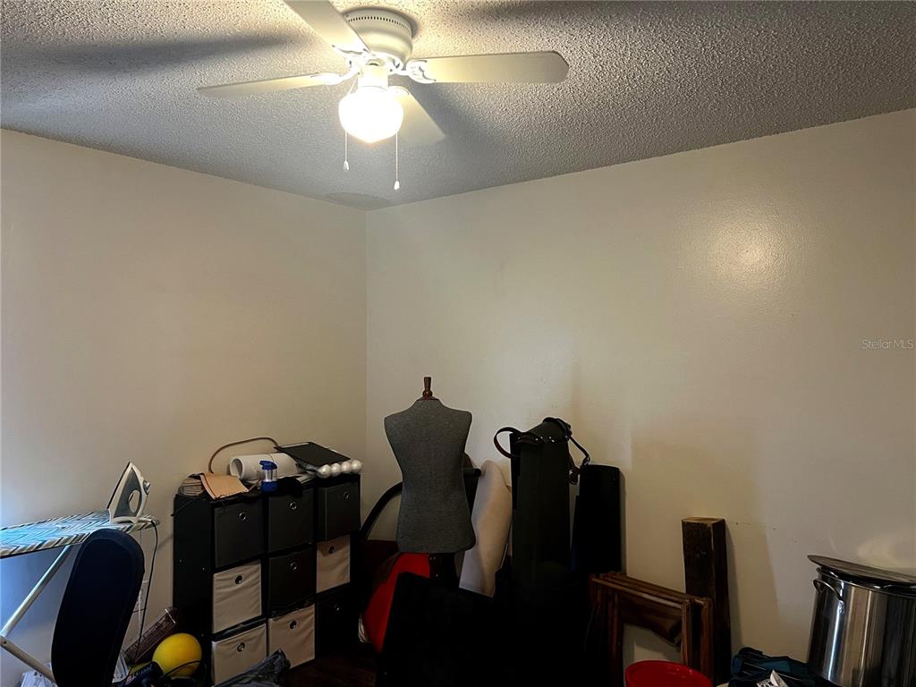 A cluttered room features a ceiling fan, a storage cubby unit, and a dress form — 4400 WHITE PINE AVENUE UNIT 70-4, ORLANDO, FL