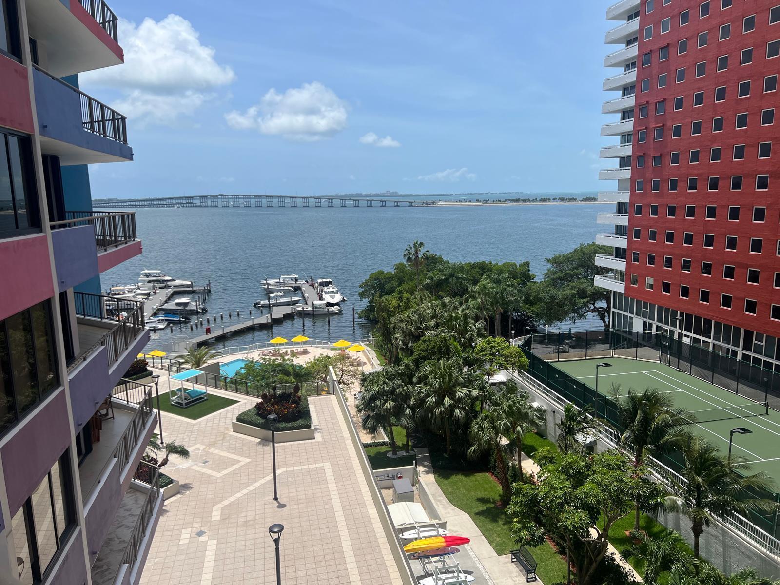 A high-angle view of a waterfront property featuring a marina, tennis court, and pool area — 1581 Brickell Avenue # 406, Miami FL 33129, MIAMI, FL