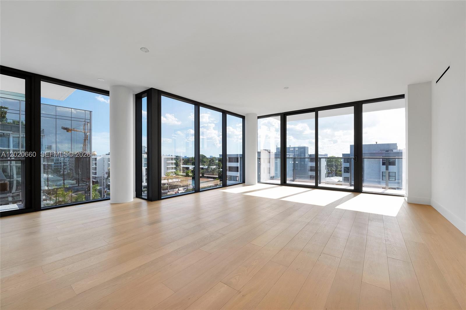 A modern living and dining area features floor-to-ceiling windows, light wood floors, and neutral furniture — 1176 97th St # 704, Bay Harbor Islands FL 33154, BAY HARBOR ISLANDS, FL