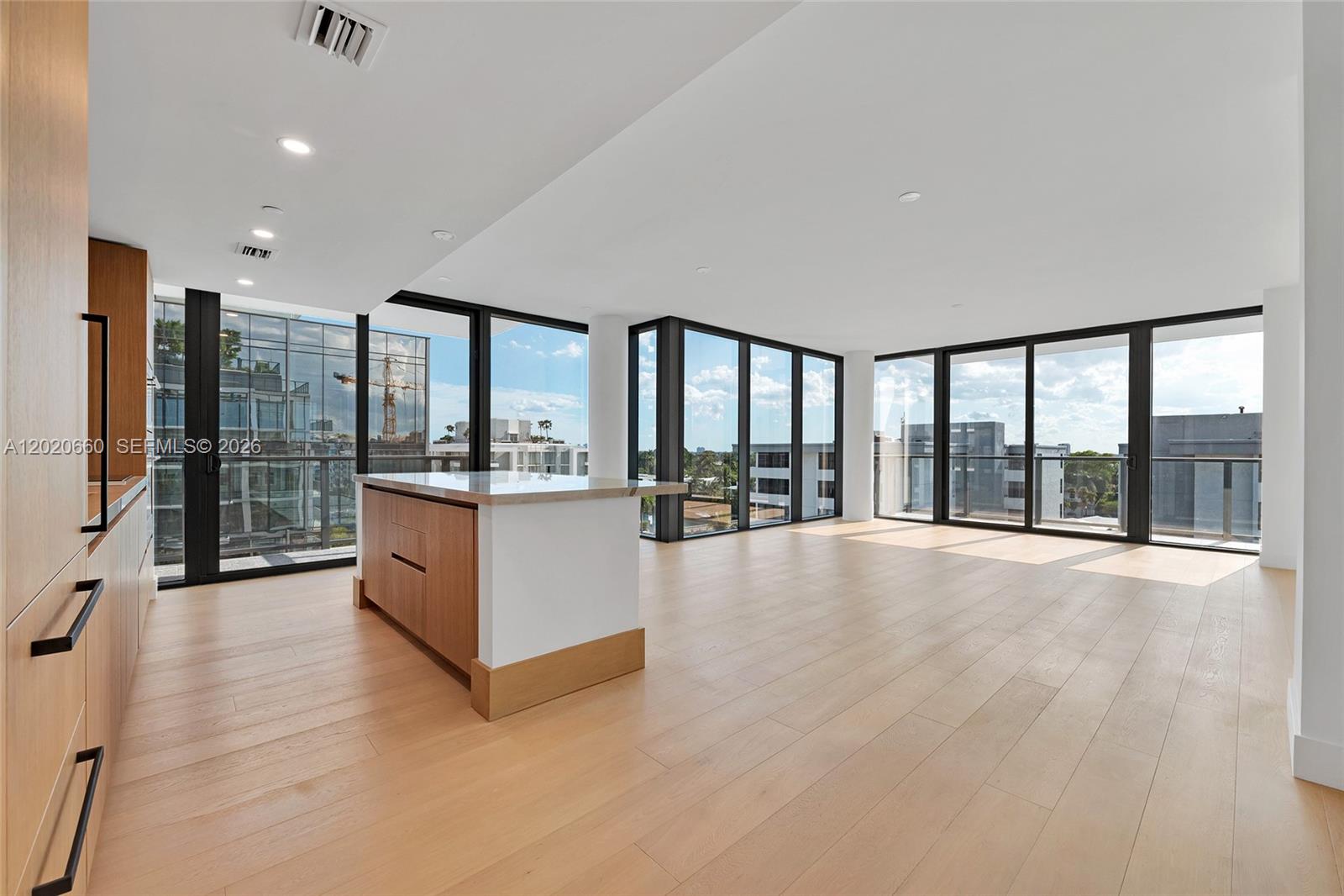 A modern open-concept living and dining area features light wood flooring and white walls — 1176 97th St # 704, Bay Harbor Islands FL 33154, BAY HARBOR ISLANDS, FL