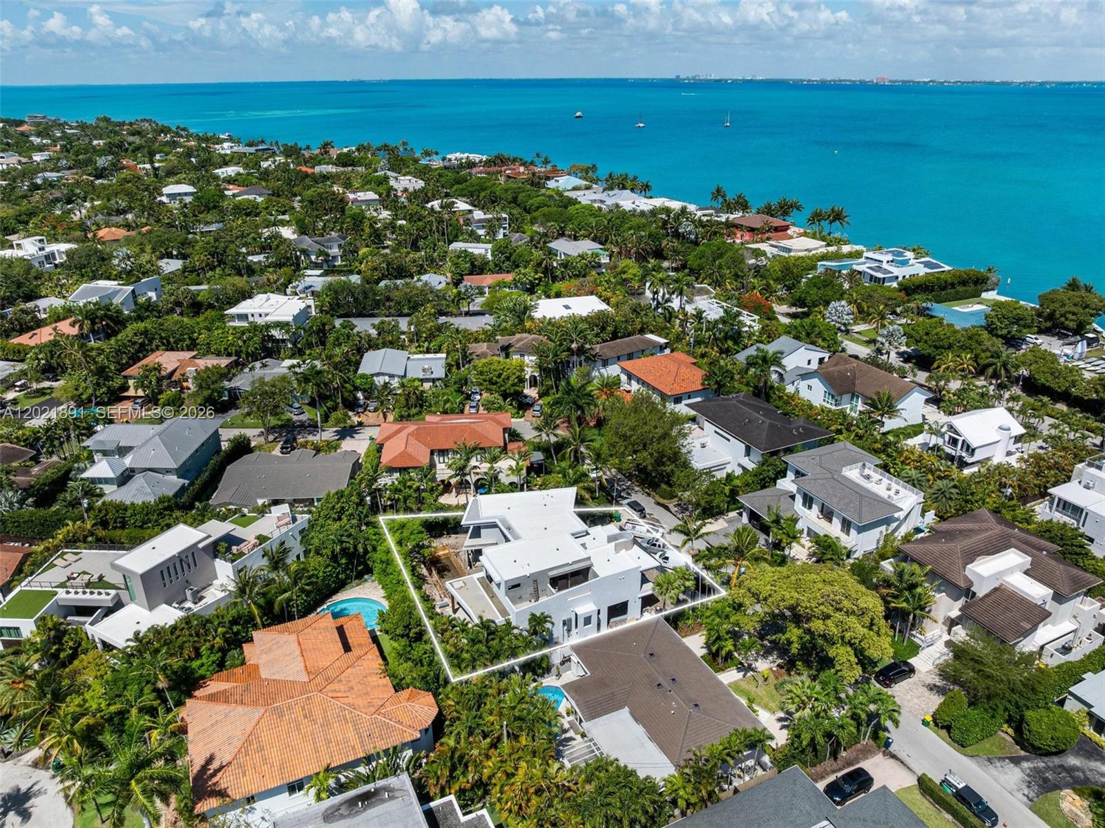 An aerial view shows a modern white house with a flat roof surrounded by lush vegetation — 238 Buttonwood Dr, Key Biscayne FL 33149, KEY BISCAYNE, FL