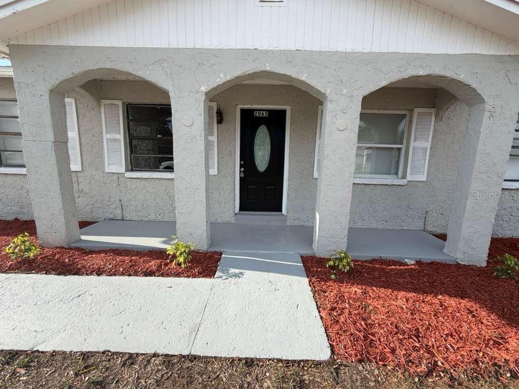 A front view of a house exterior featuring a covered porch with arched concrete pillars — 2065 BALFOUR CIRCLE, TAMPA, FL