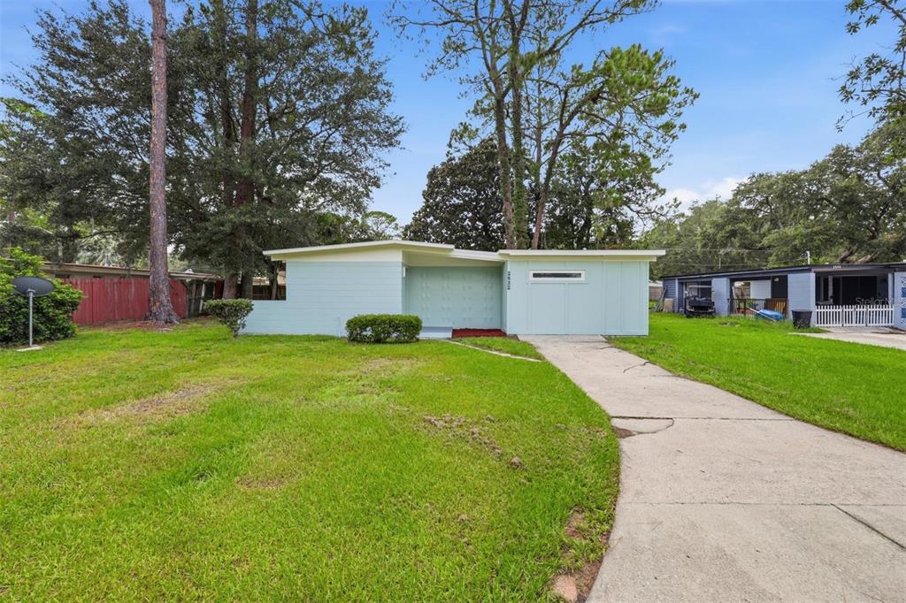 A light blue, single-story house with a flat roof and a concrete driveway — 2832 NE 11TH TERRACE, GAINESVILLE, FL