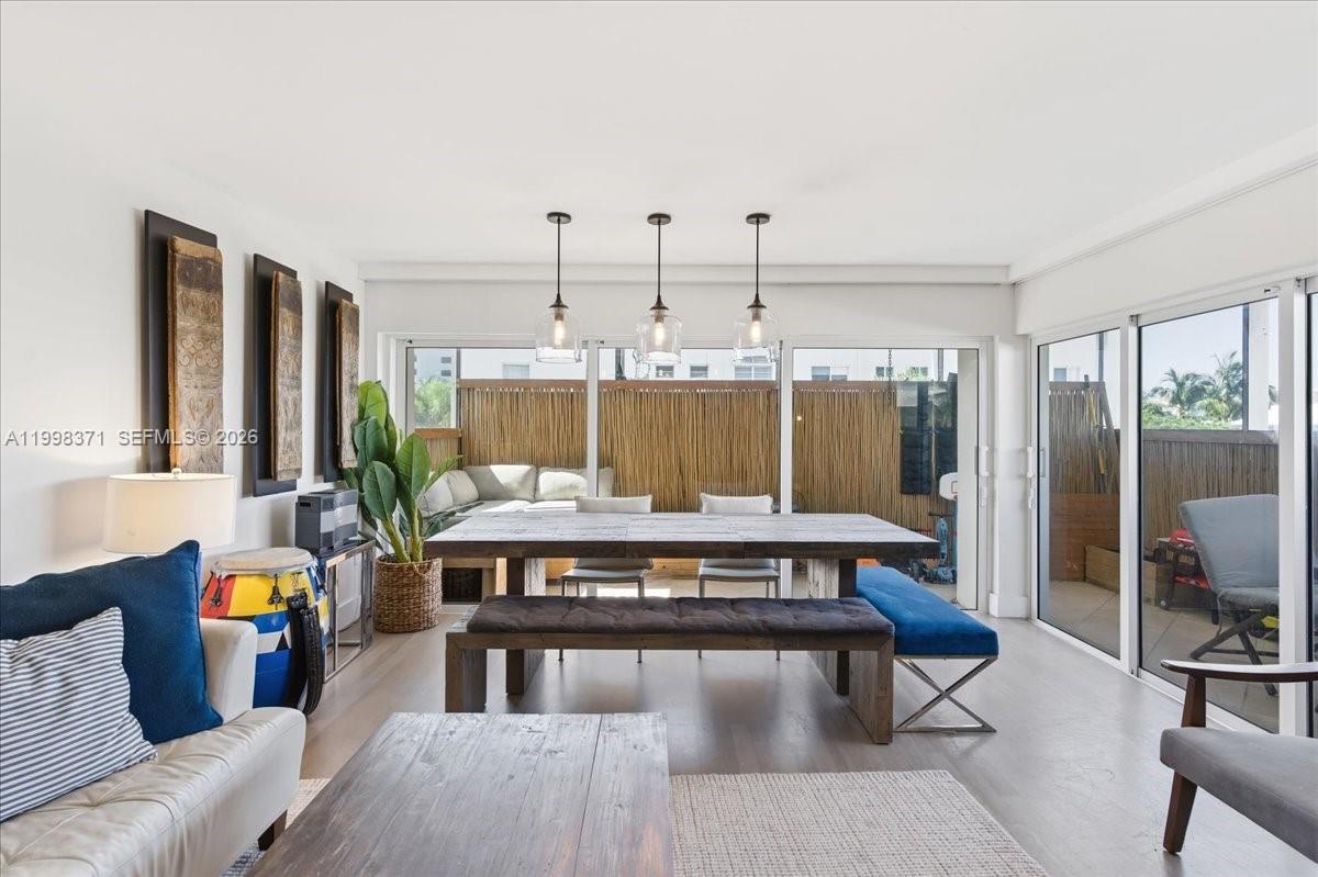 A dining area with a wooden table and benches sits before a glass-walled patio — 550 Ocean Drive # 3H, Key Biscayne FL 33149, KEY BISCAYNE, FL