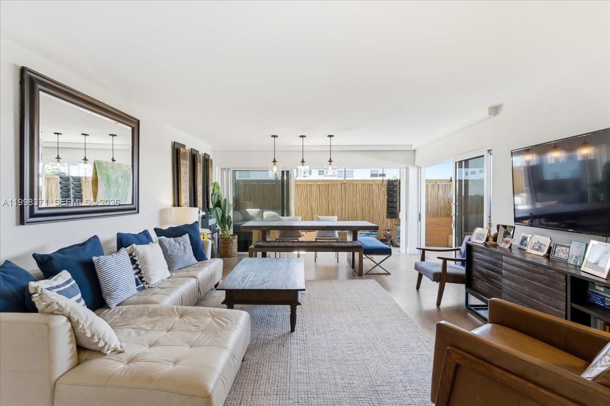 A bright living room features a large sectional sofa, wooden dining table, and sliding glass doors — 550 Ocean Drive # 3H, Key Biscayne FL 33149, KEY BISCAYNE, FL