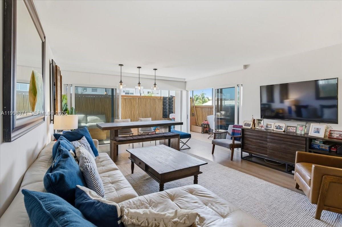 A living room features a sectional sofa, wooden coffee table, dining area, and sliding doors — 550 Ocean Drive # 3H, Key Biscayne FL 33149, KEY BISCAYNE, FL