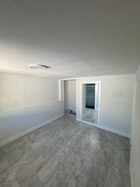 A room with light gray walls, a white ceiling, and gray tile flooring — 330 S. BUENA VISTA AVENUE, ORLANDO, FL