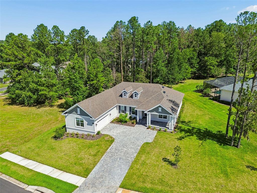 An aerial view shows a single-story house with a paved driveway and a large yard — 4880 HICKORY OAK DRIVE, BROOKSVILLE, FL