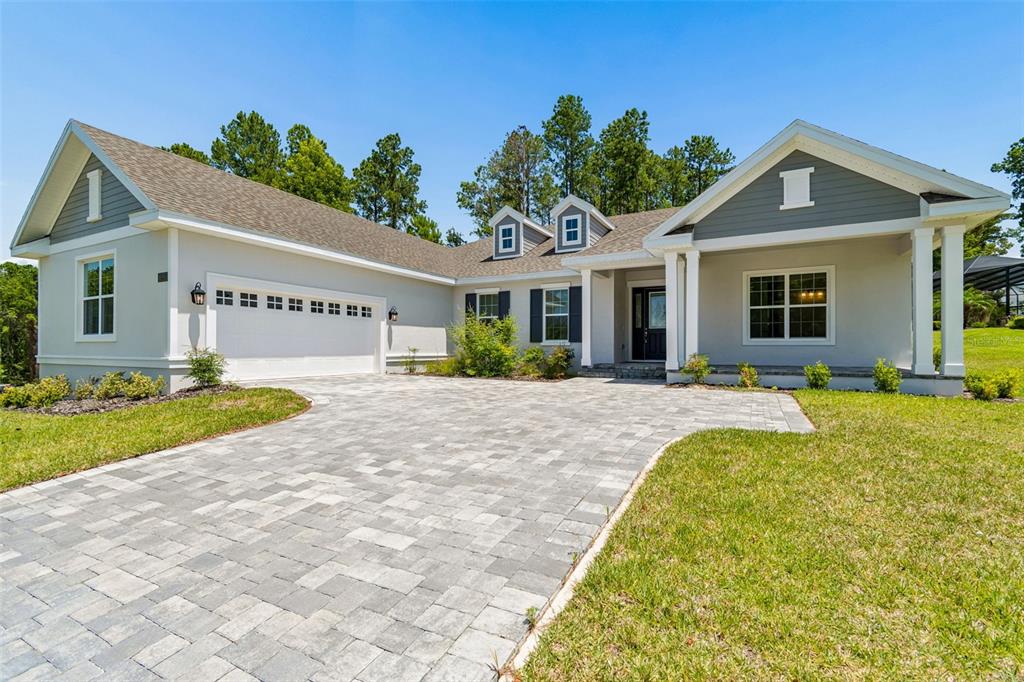 A single-story house with a gray exterior, white trim, and a paved driveway — 4880 HICKORY OAK DRIVE, BROOKSVILLE, FL