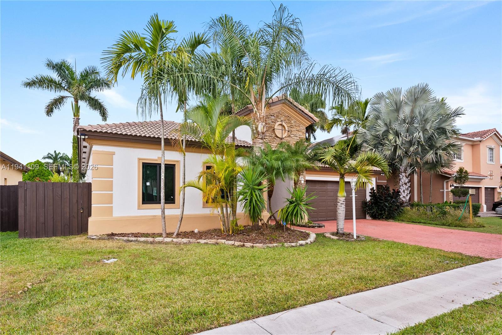 A single-story house with a stone facade, palm trees, and a red brick driveway — 918 NE 36th Ave, Homestead FL 33033, HOMESTEAD, FL