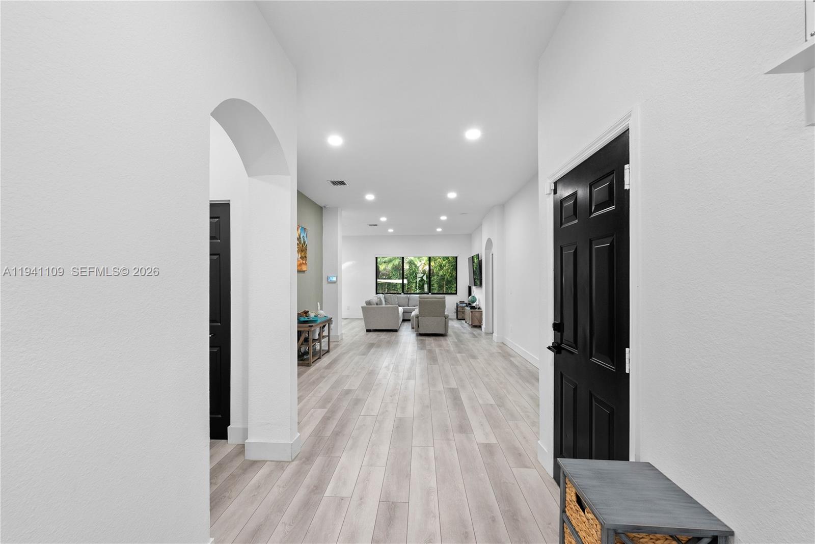 A bright hallway with light wood flooring leads into an open-concept living room — 918 NE 36th Ave, Homestead FL 33033, HOMESTEAD, FL