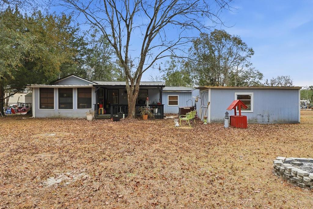 A light blue single-story house with a covered porch, attached shed, and a wishing well — 6771 W SASSER STREET, HOMOSASSA, FL