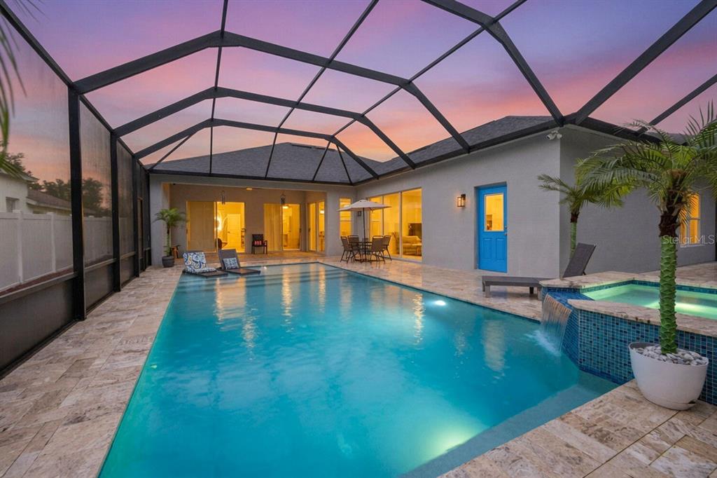 A screened-in swimming pool and spa with a patio area at sunset — 5849 RIVA RIDGE DRIVE, WESLEY CHAPEL, FL