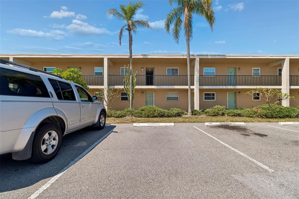 A silver SUV is parked in front of a two-story apartment building with palm trees — 12300 PARK BOULEVARD UNIT 221, SEMINOLE, FL