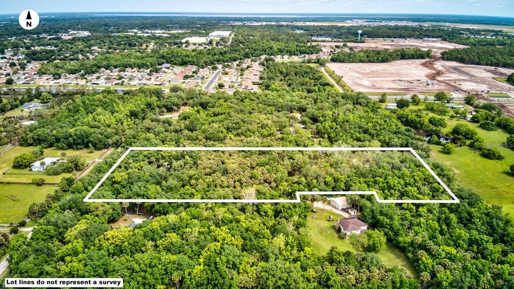 An aerial view shows a rectangular plot of land outlined in white amidst dense trees — S MELLONVILLE AVENUE, SANFORD, FL