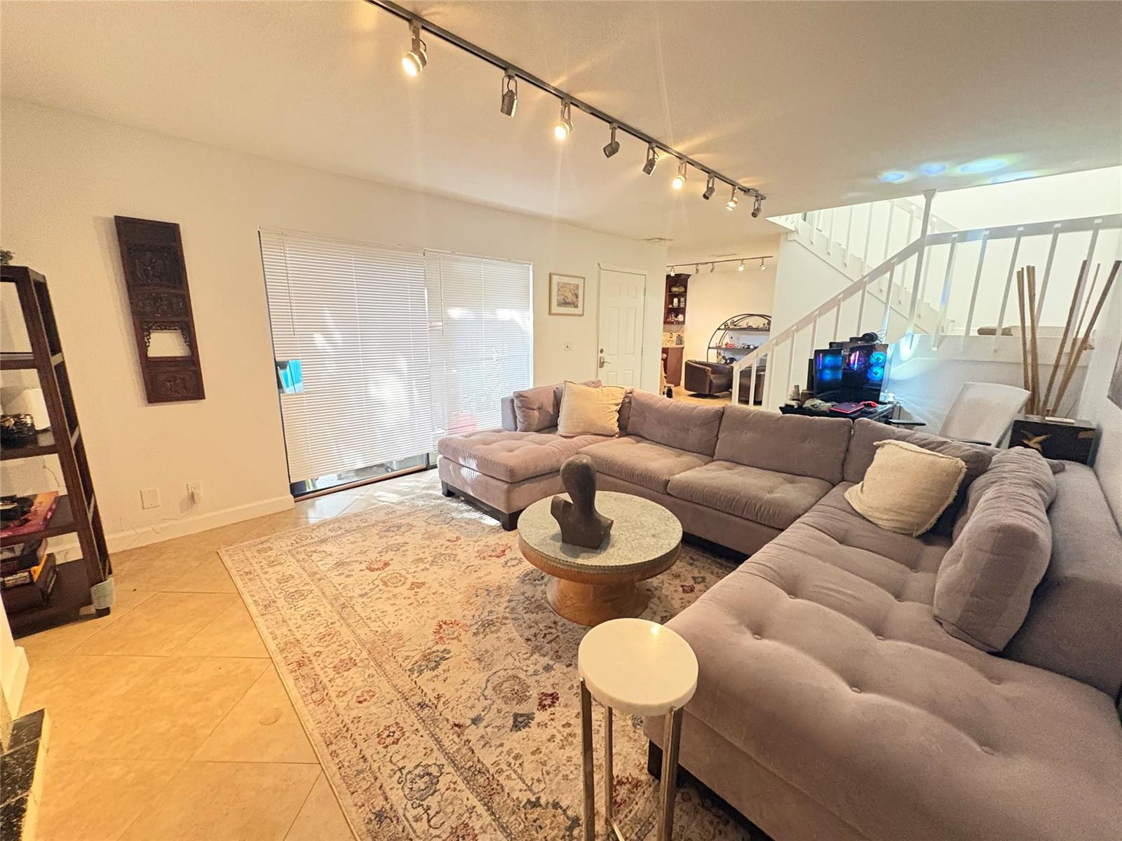 A living room features a large gray sectional sofa, a patterned rug, and track lighting — 294 Arabian Road # 294, Palm Springs FL 33461, PALM SPRINGS, FL