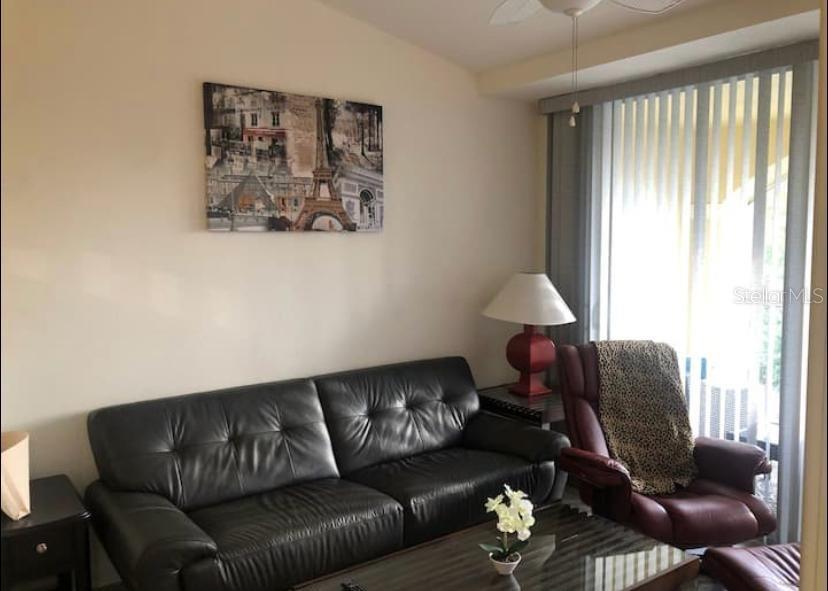 A living room features a black leather sofa, a red recliner, and a Paris-themed wall canvas — 4105 RESIDENCE DRIVE UNIT 717, FORT MYERS, FL