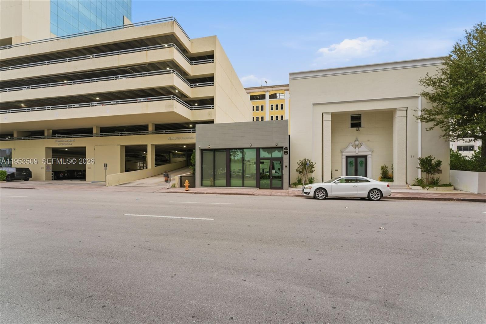 A street-level view shows a modern storefront between a parking garage and a classic building — 45 Valencia Ave, Coral Gables FL 33134, CORAL GABLES, FL