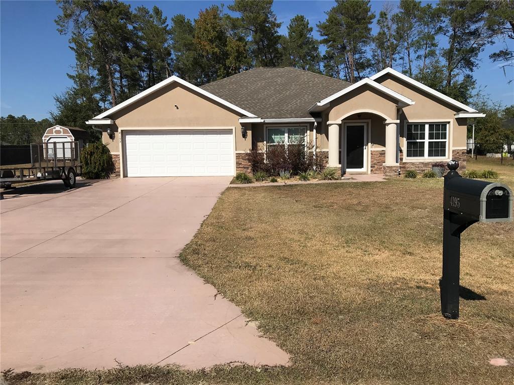 A single-story house with a tan stucco exterior, a two-car garage, and a concrete driveway — 4195 SW 114TH STREET, OCALA, FL